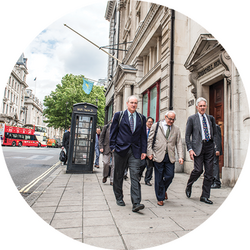 Faculty and conference participants walk down a London street.