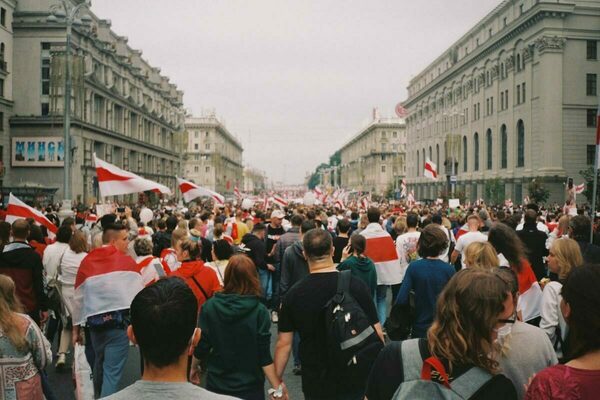 People walking in Belarus in protest with white and red flags.