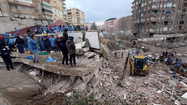 The cleanup of the wreckage of a collapsed building, Diyarbakır, Turkey, February 2023. Voices of America, Public Domain via Wikimedia Commons.