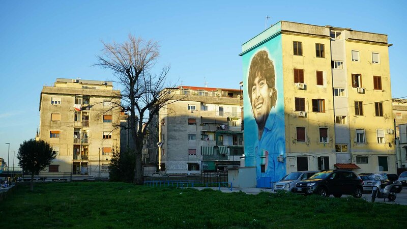 Mural of Maradona on the side of a building in a Naples suburb