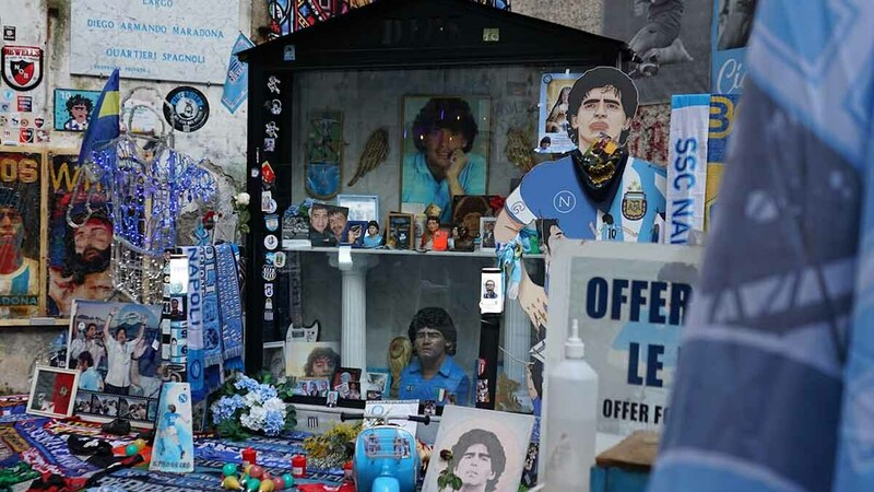Maradona memorabilia beneath a mural.