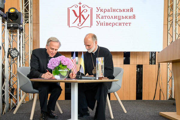 Father John Jenkins and Borys Gudziak sign a memorandum of understanding.