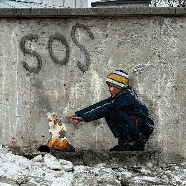 SOS. Street Art. Boy warms hands over fire.