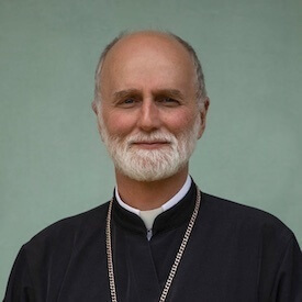 Headshot of Archbishop Borys Gudziak. He is sitting in front of a pale green backdrop, and he is wearing priestly garments.