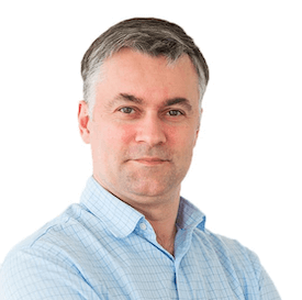 Headshot of Andriy Kurochka, who is standing in front of a white background and wearing a blue shirt.