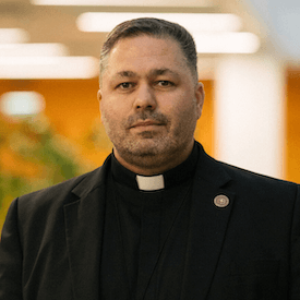 Headshot of Fr. Yuriy Shchurko, who is wearing a black blazer over a black shirt.