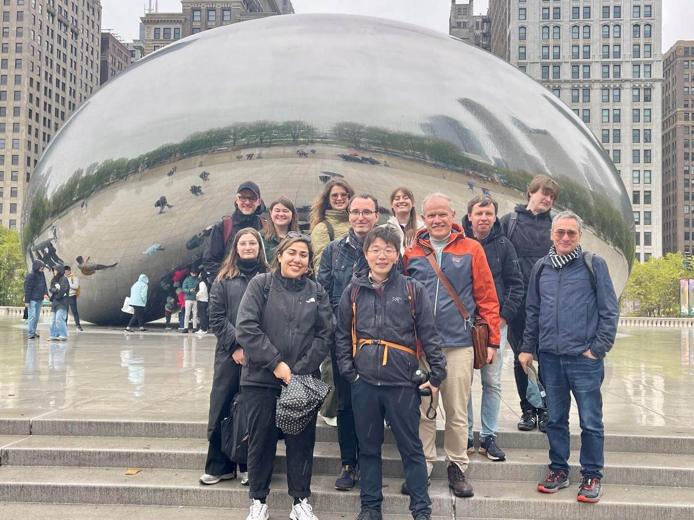 A group of people stand in front of a reflective sphere iat Millennium Park in Chicago.